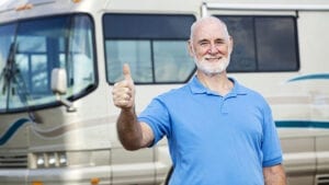 man gives thumbs up while inspecting RV repair coverage